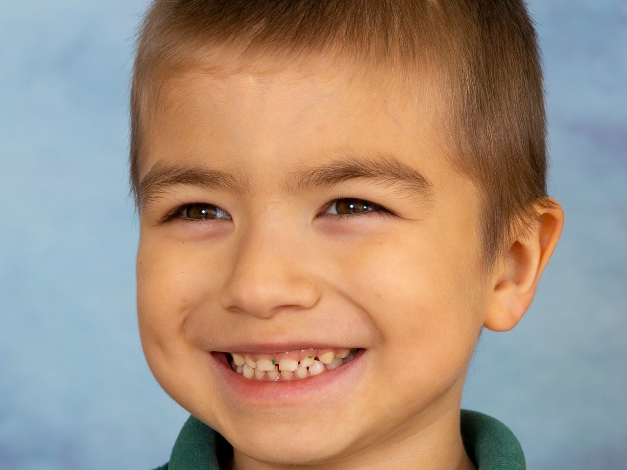 Cheeky little chappy with an amazing smile for his autism friendly school photograph session