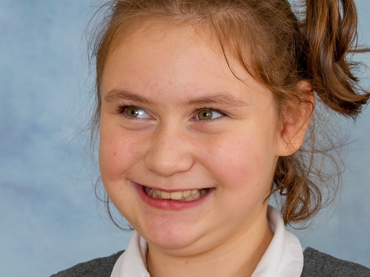 Cheeky smile from this adorable young girl with complex needs having her school photograph