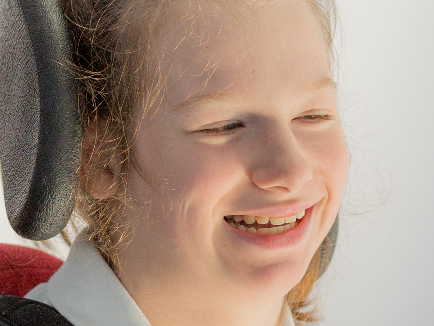 Teenage disabled girl in wheelchair smiling for school portrait
