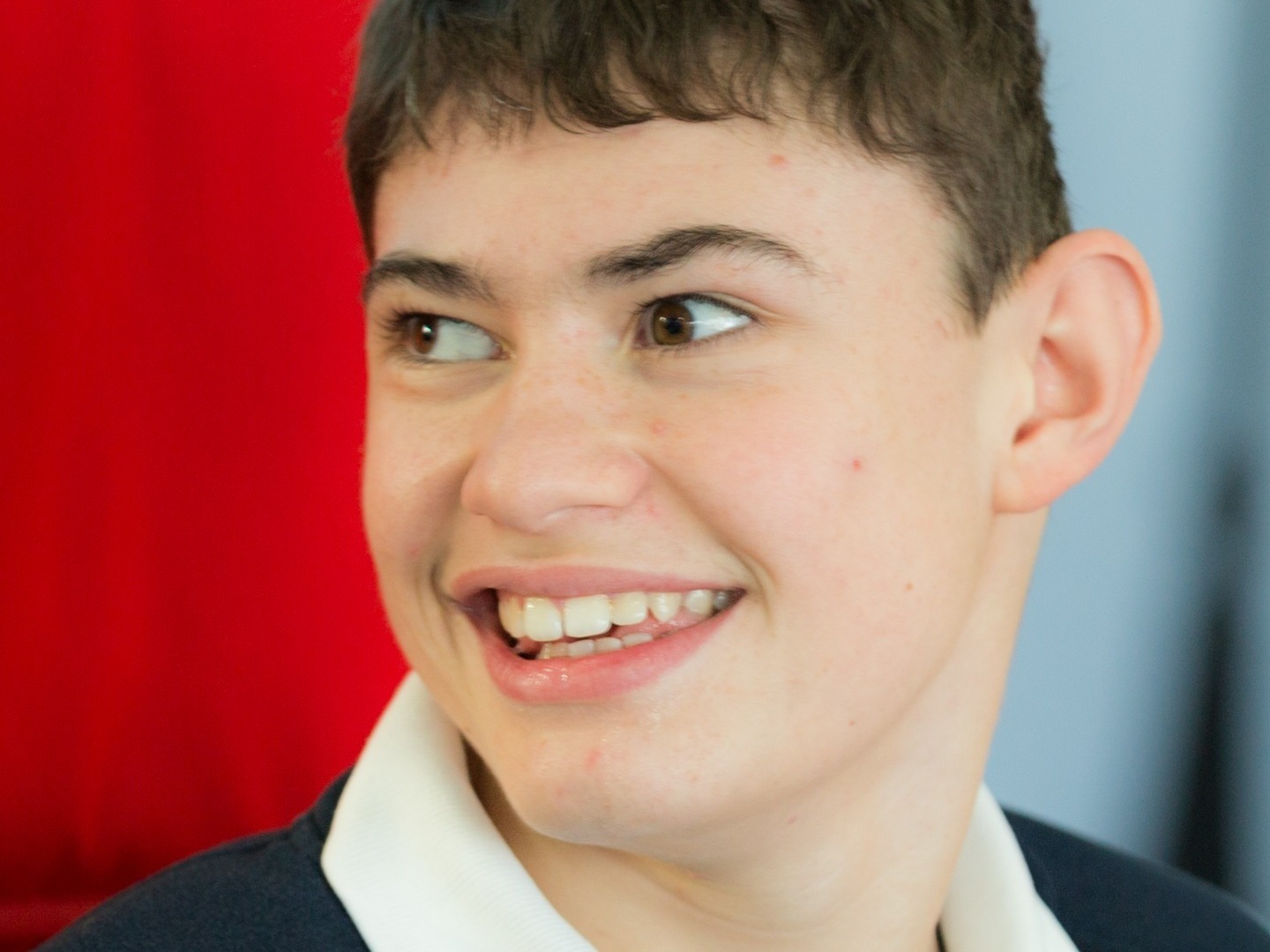 Teenage boy with learning difficulties in school uniform for school photo