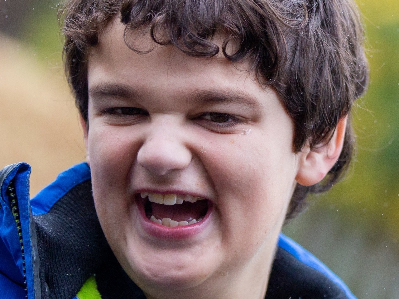 This happy young man with learning difficulties is enjoying his outdoor school photography session
