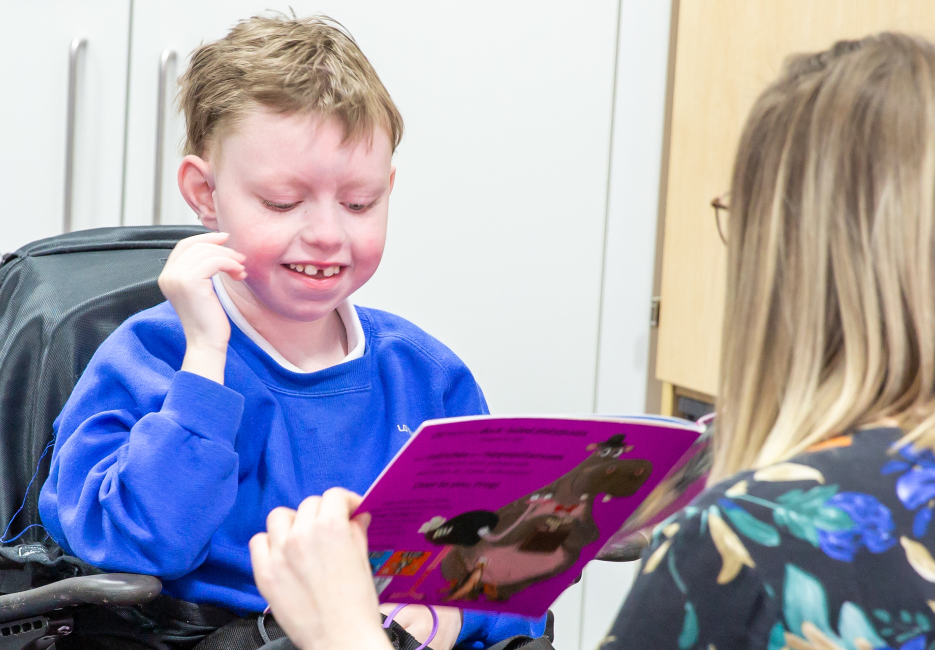 A young boy with a Au-kline syndrome engaging in learning at a special needs school