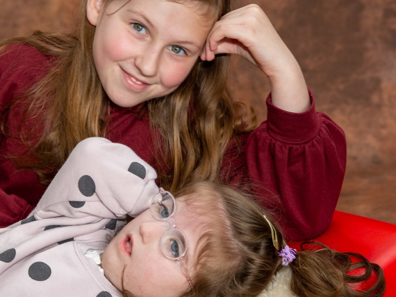 A young girl with a medical condition having a photograph with her sister whilst visiting Hospice Care