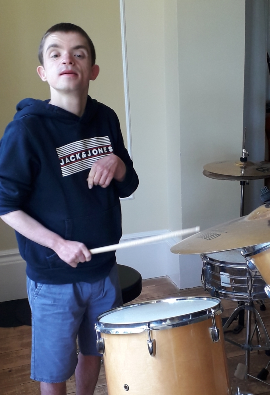 James enjoying time on the drums on holiday at Hartlands, Isle of Wight - Specialist Autistic Holiday Centre