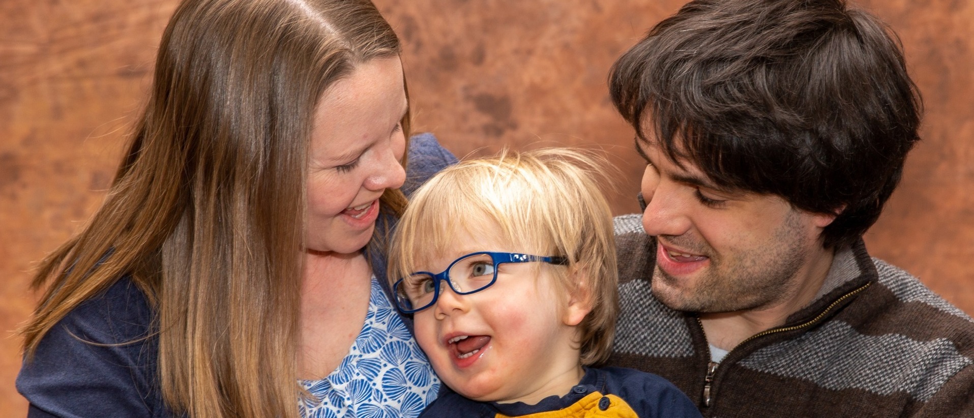 A child with complex medical needs having a family photograph with his mother and father at Keech Hospice